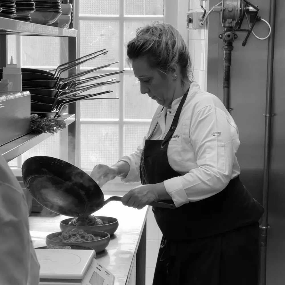 Céleste, la mamma, fait sauter les pâtes en cuisine