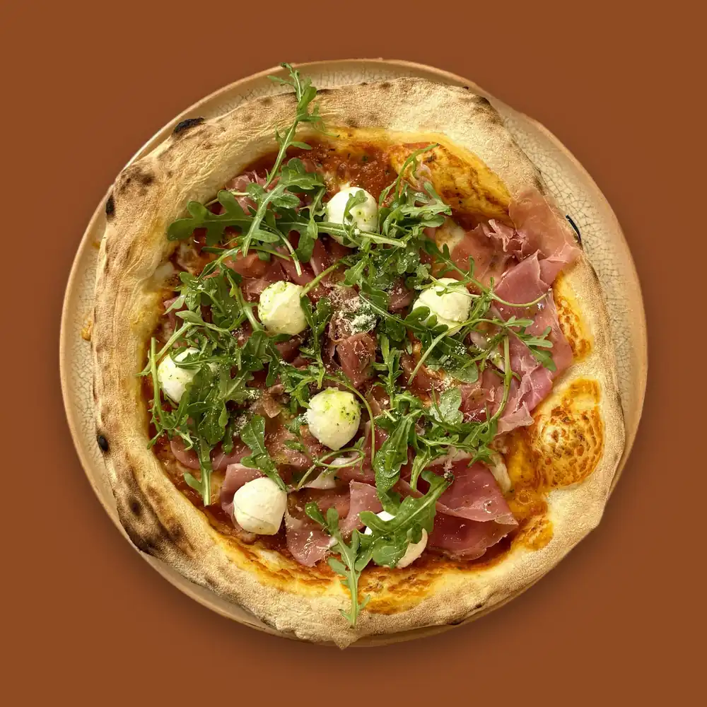 Pizza Parma — sauce tomate, mozzarella fior di latte, jambon de Parme, billes de mozzarella di bufala, roquette