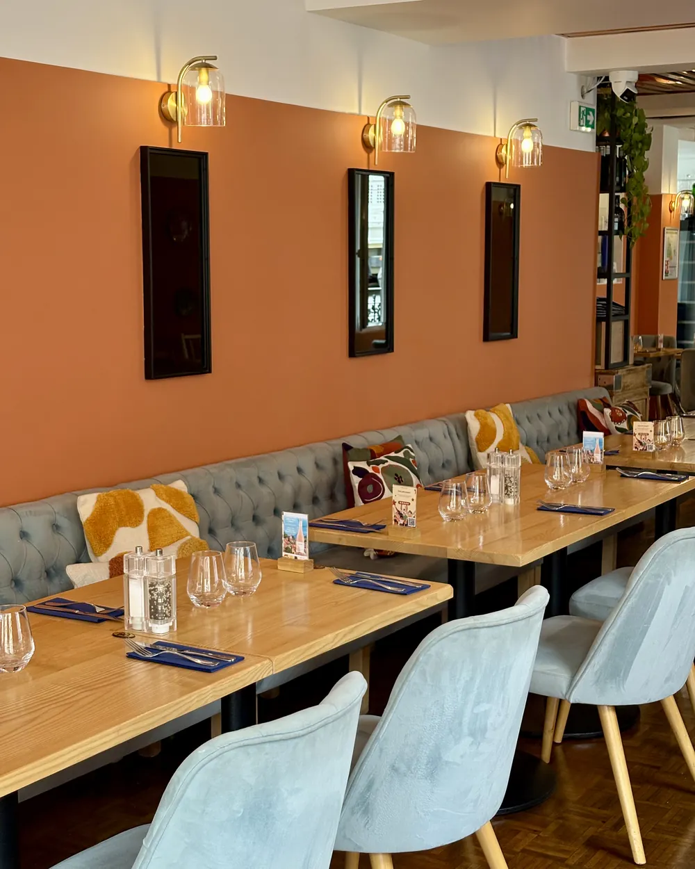 La salle de L’Osteria, murs terracotta et banquette bleue